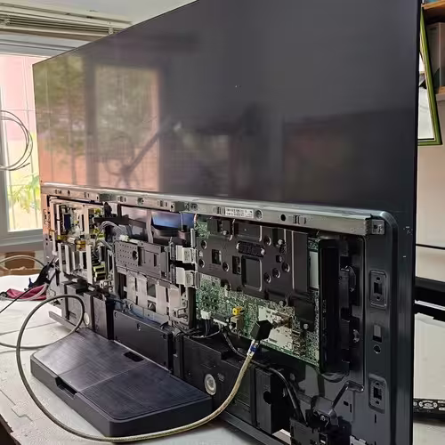 Técnico com estação de solda reparando uma placa principal de TV